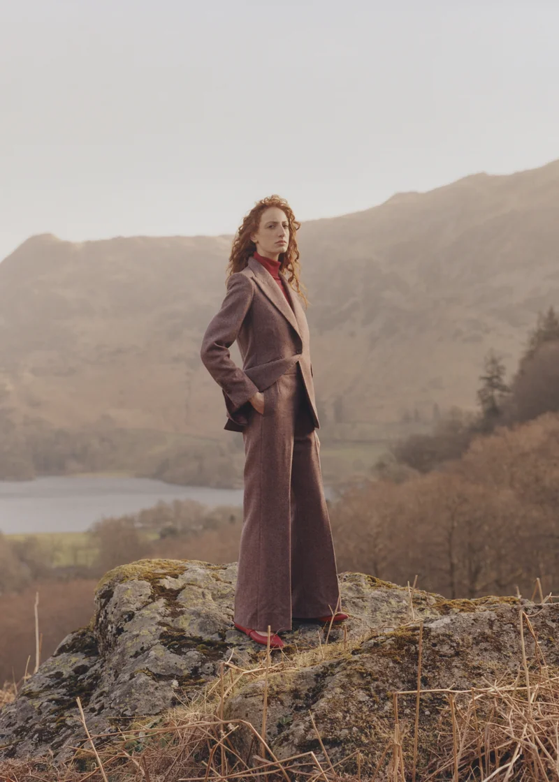 Heather tweed trouser suit on a hillside above a lake